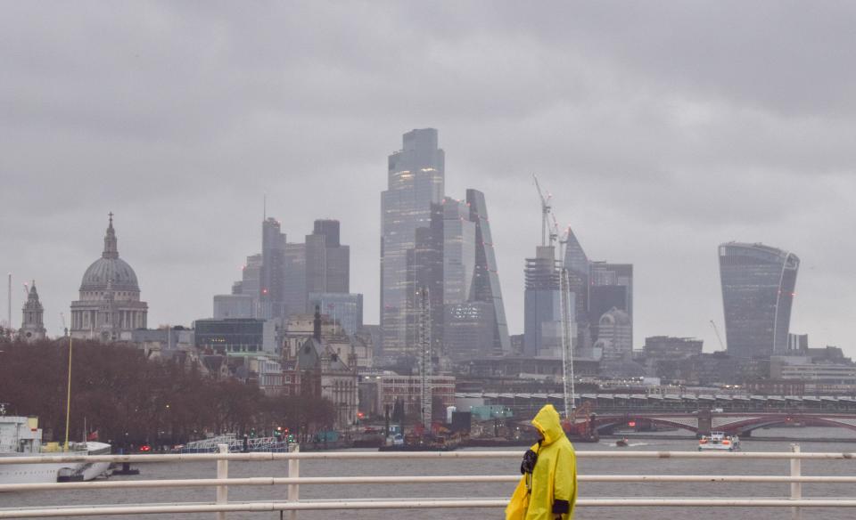 London, England, UK. 27th Dec, 2023. A predestrian walks across Waterloo Bridge past the City of London skyline, the capital's financial district, amidst strong winds and rain as Storm Gerrit hits the UK. (Credit Image: © Vuk Valcic/ZUMA Press Wire) EDITORIAL USAGE ONLY! Not for Commercial USAGE!