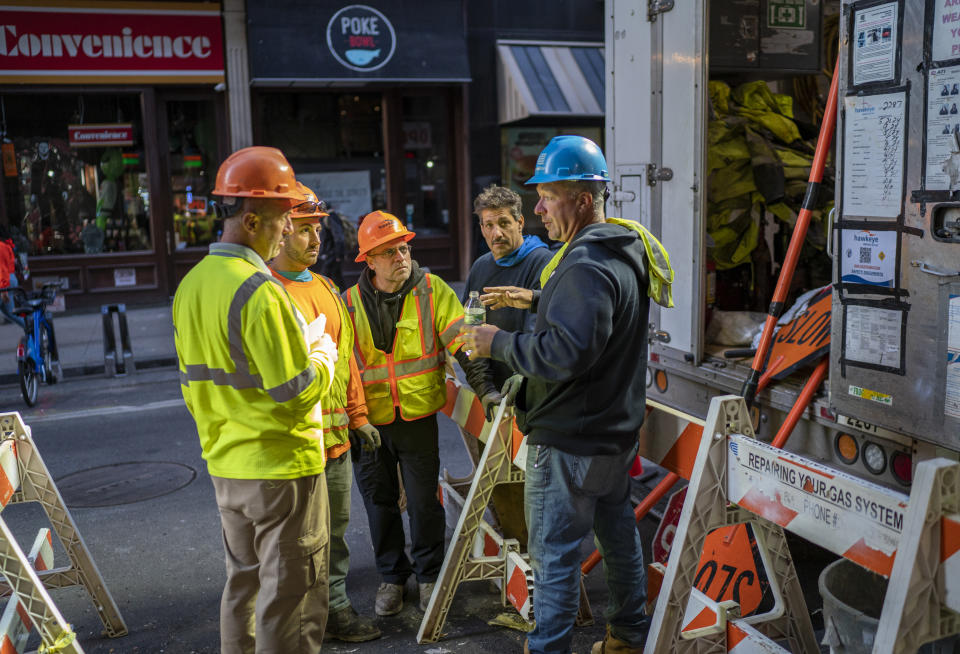 NEW YORK, NEW YORK - OCTOBER 13: A group of construction workers holds a meeting about an underground pipe repair on October 13, 2023 in New York City. (Photo by Robert Nickelsberg/Getty Images)