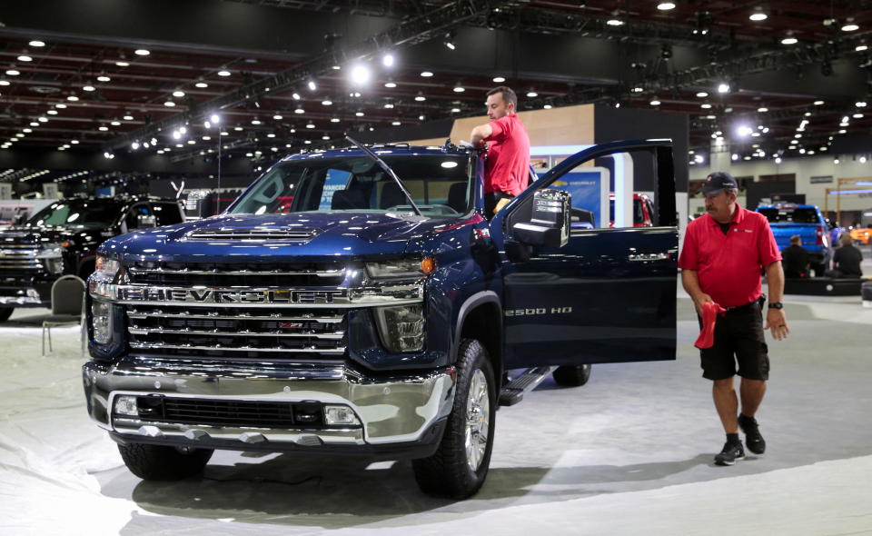 Workers prepare a displayed 2022 Chevrolet Silverado pickup truck before media day of the North American International Auto Show in Detroit, Michigan, U.S. September 13, 2022.   REUTERS/Rebecca Cook