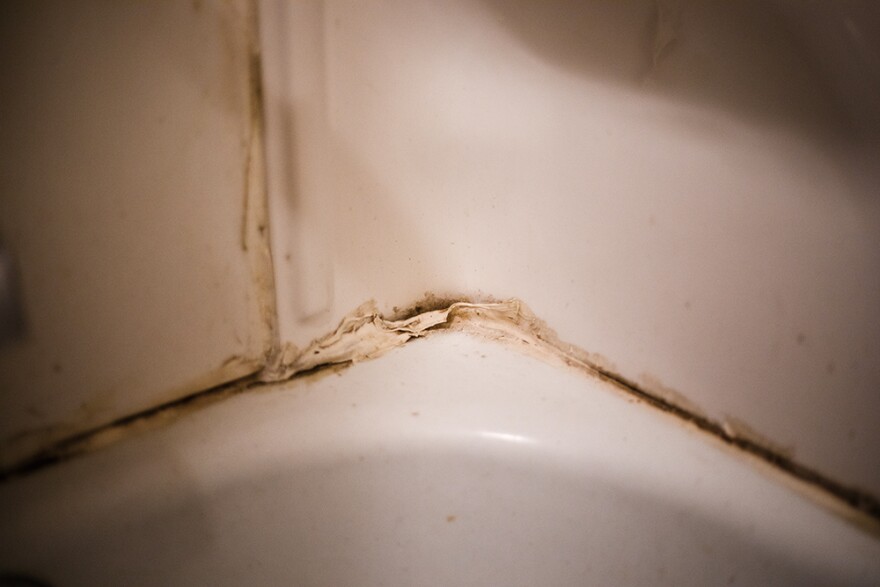 Mold and grim peel caulk off the bathtub inside of Angelene Morgan and Gary Jones’ apartment on Tuesday, Jan. 23, 2024, at Pleasant View Gardens in Ferguson. The two have dealt with bugs, black mold, and an unresponsive landlord, while living at the apartment complex. 