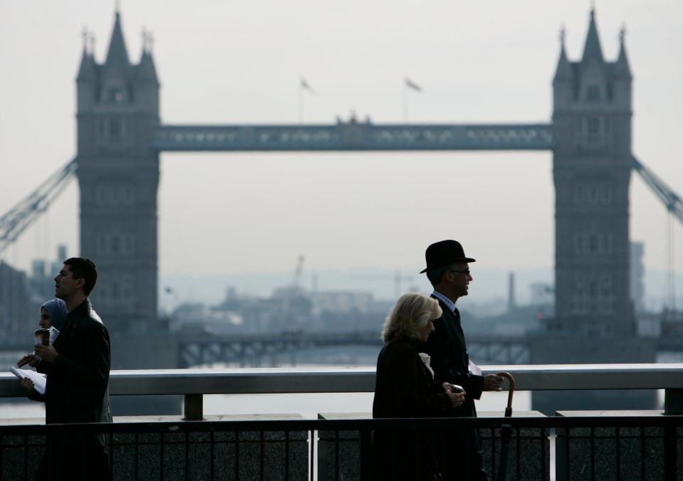 FTSE was lower on Wednesday. People cross London Bridge, backdropped by central London's landmark Tower Bridge