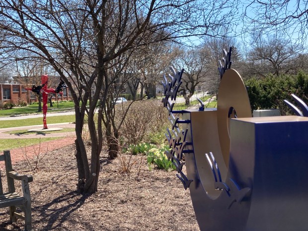 Hilde DeBruyne's sculpture "Reaching for the Sky" stands in the foreground and Jack Howard-Potter's work "Marmeg" is situated further along the path in Leavitt Park in Flossmoor. (Paul Eisenberg/Daily Southtown)