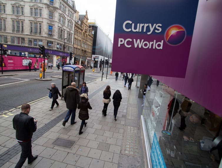 Shoppers walking past Currys PC World on London's Oxford Street