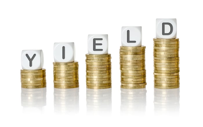 Five stacks of coins with lettered blocks on top of each that spell out "yield".