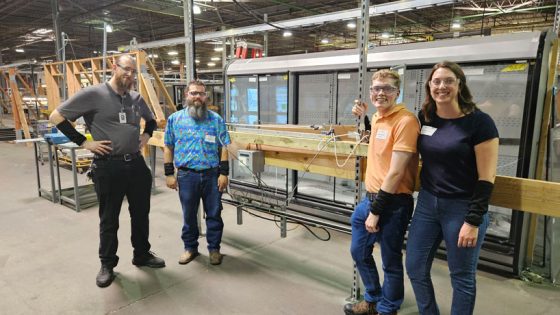 UMSL mechanical engineering students near a device they created for Hussman Corporation