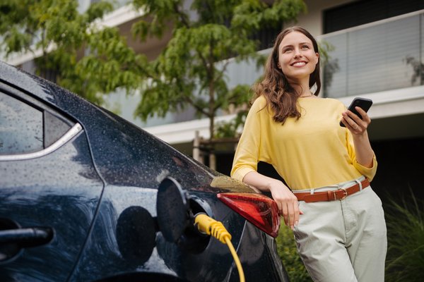 Driver charges an electric car.