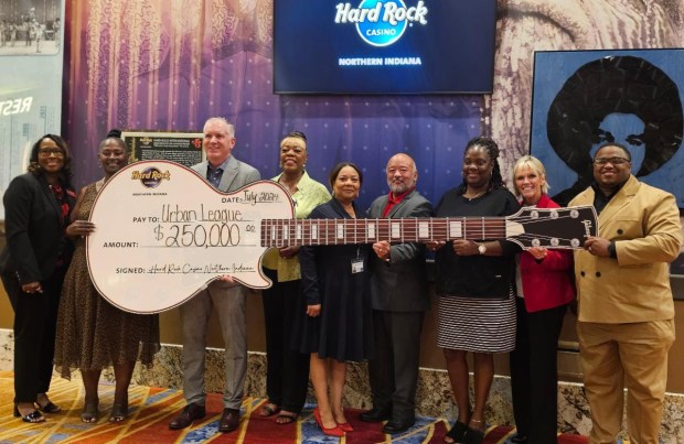 Matt Schuffert, third from left, president of Hard Rock Casino Northern Indiana, presents a guitar-shaped check to Vanessa Allen McCloud, fourth from left. The $250,000 donation will fund 30 scholarships to Indiana University Northwest for Gary graduates. (Photo provided by Hard Rock Casino)