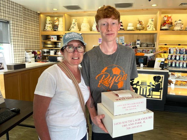 Meghan and Emmett Kingzette purchase treats Tuesday at the Orland Park Bakery to help the Ryan Plowman Scholarship Fund at Shepard High School. (Jeff Vorva/Daily Southtown)