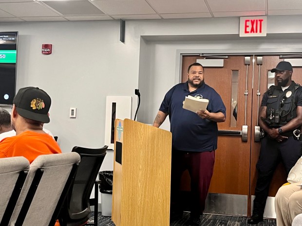 Keith Price, who serves as food pantry manager for Thornton Township, holds up what he said were invoices and statements for bills brought to the township board July 16, 2024. (Olivia Stevens/Daily Southtown)