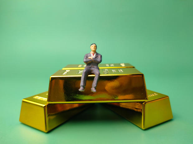 Gold bar with miniature people, Business and financial concept 