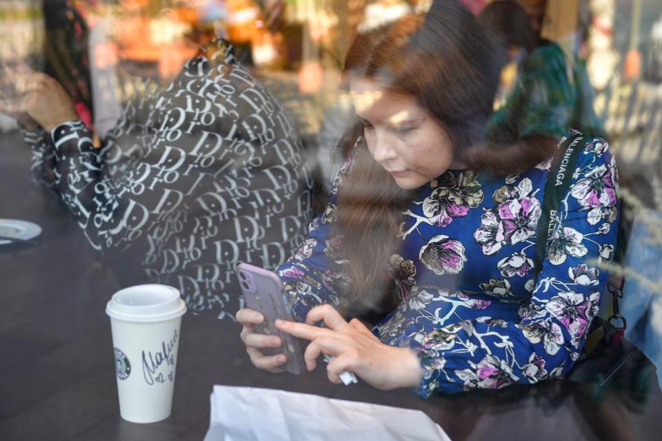 A woman takes photos of her drink at the newly-opened Stars Coffee, a chain that opened in former Starbucks coffee shops in Moscow, Russia, on Aug. 22, 2022. (Photo by Alexander Zemlianichenko Jr/Xinhua via Getty Images)