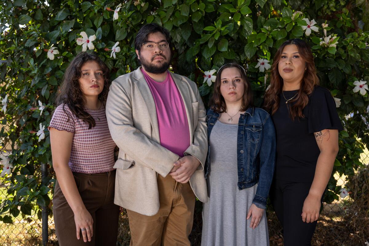 Three women and a man stand outdoors. 