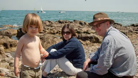 Matt Prince Max Prince as a toddler on the beach with his parents looking on