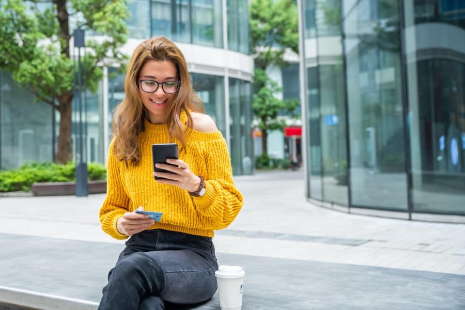 Person seated looking into a hand-held electronic mobile device.