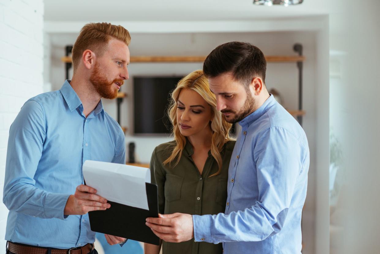 Real estate agent going through the paperwork with the young couple