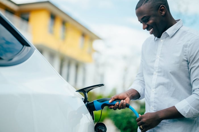 A person charging an EV.