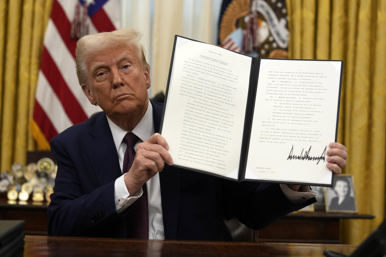 President Donald Trump signs an executive order relating to cryptocurrency in the Oval Office of the White House, Thursday, Jan. 23, 2025, in Washington. (AP Photo/Ben Curtis)