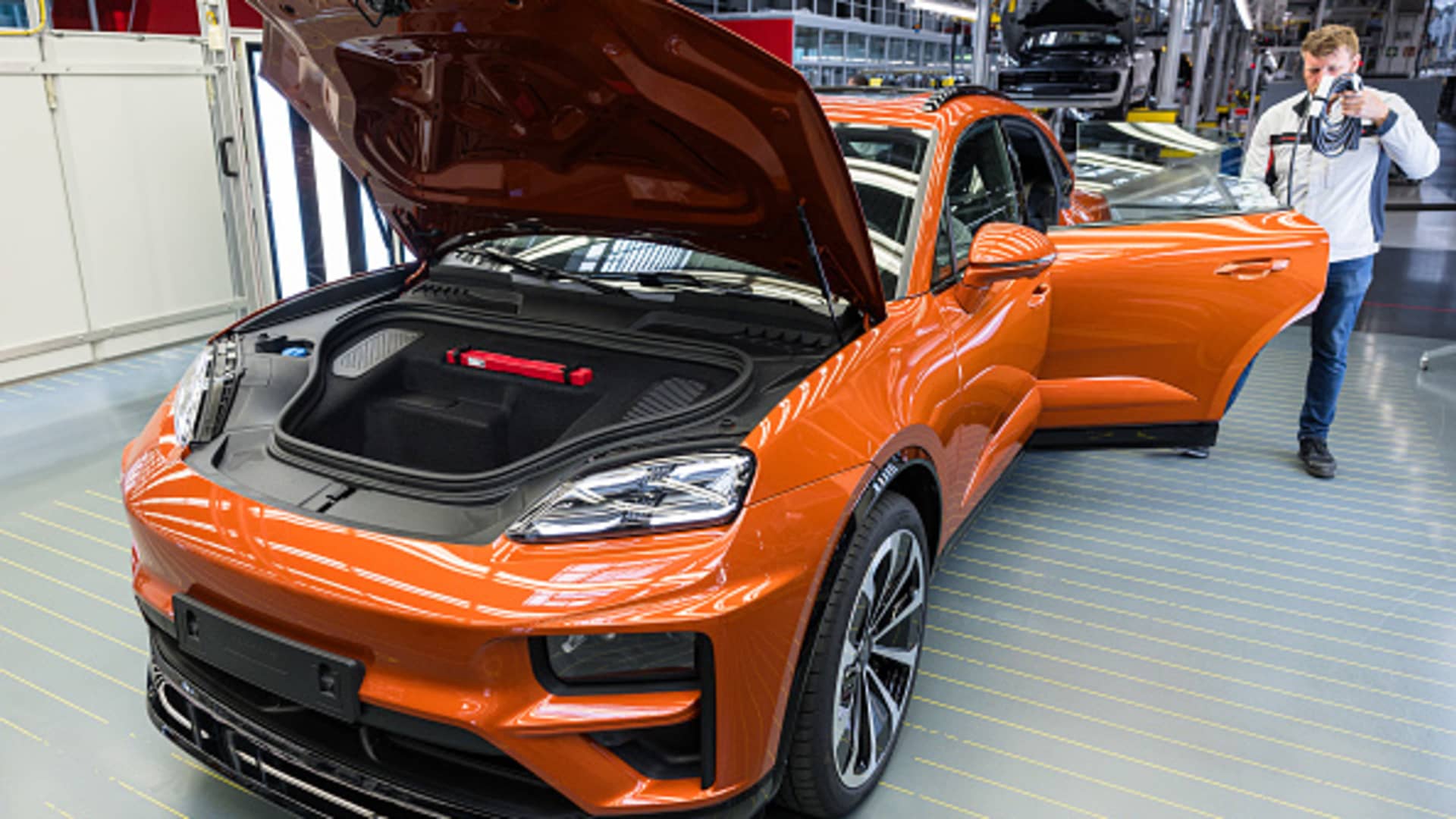 A worker checks the quality of the all-electric Porsche Macan at the Porsche assembly plant on May 6, 2024, in Leipzig, Germany.