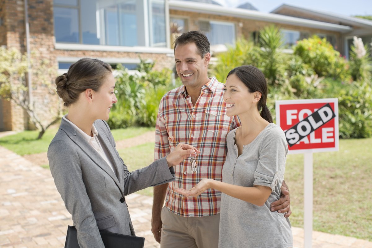 Couple receiving keys to their new home.