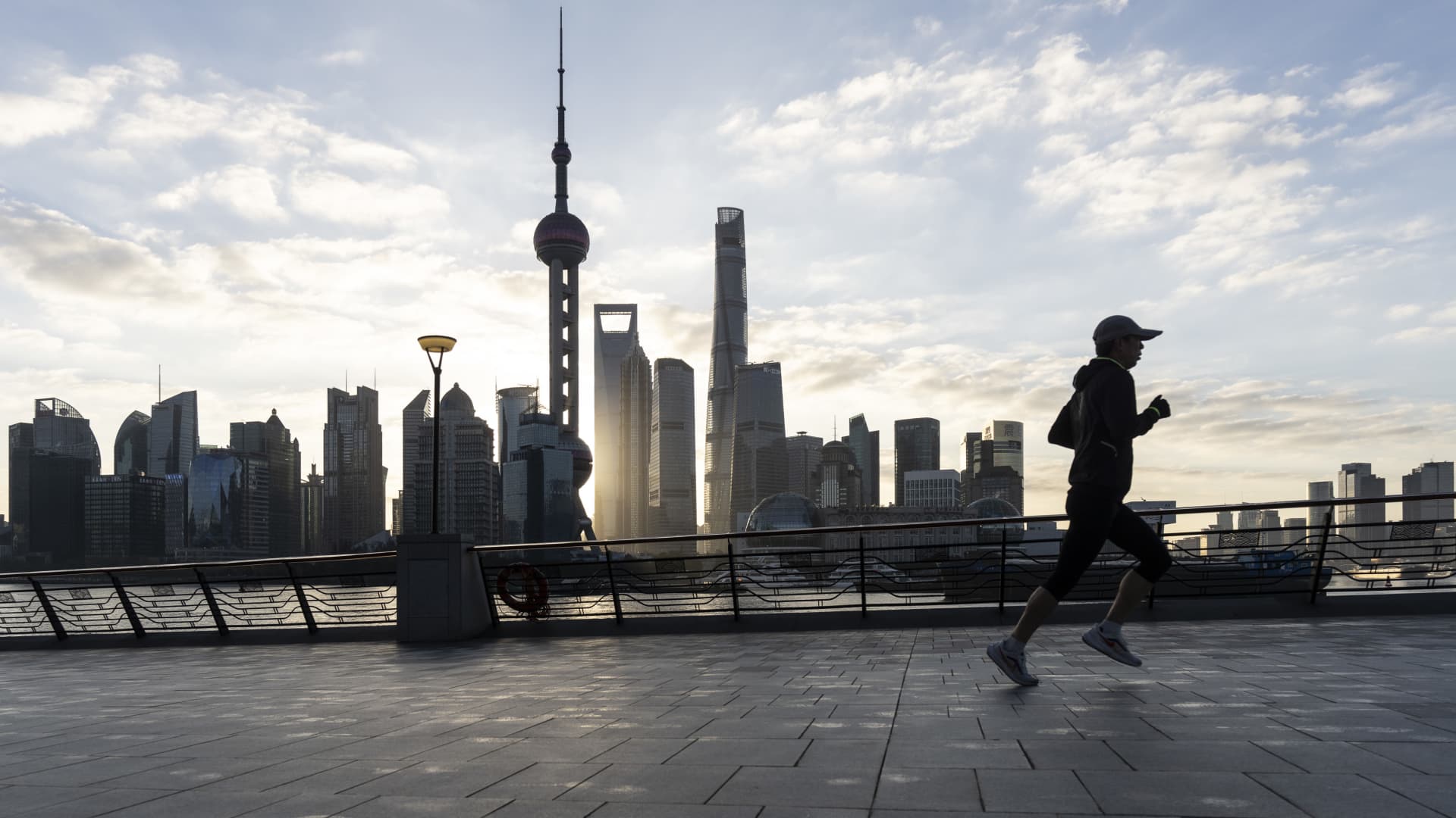 A pedestrian jogs along the Bund across from buildings in Pudong's Lujiazui Financial District in Shanghai, China, on Thursday, Jan. 2, 2025.