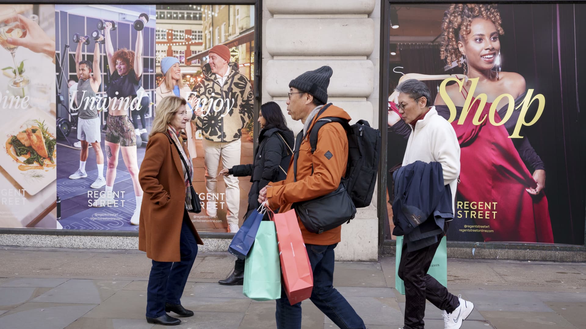 Shoppers walk past temporary billboards for the Regent Street retail business community, on Feb. 25, 2025, in London, England.