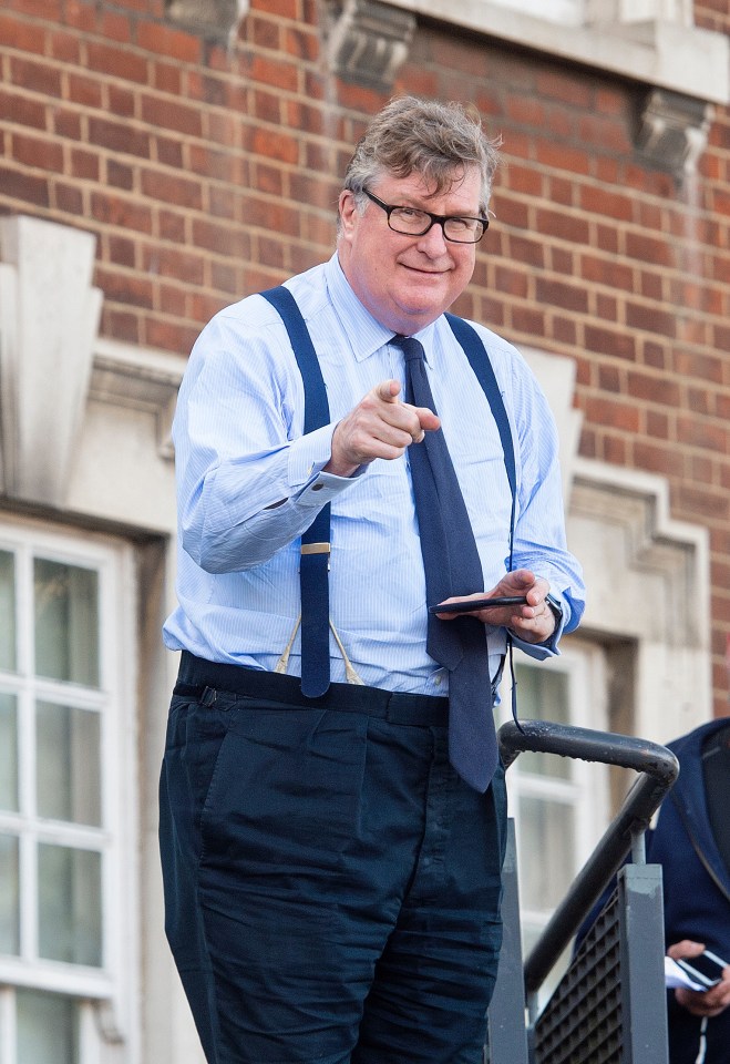 Crispin Odey pointing at the camera outside a courthouse.