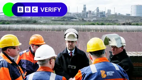 Reuters British Steel staff standing in front of blast furnaces during Deputy Prime Minister Angela Rayner's visit to the site in Scunthorpe, Lincolnshire.