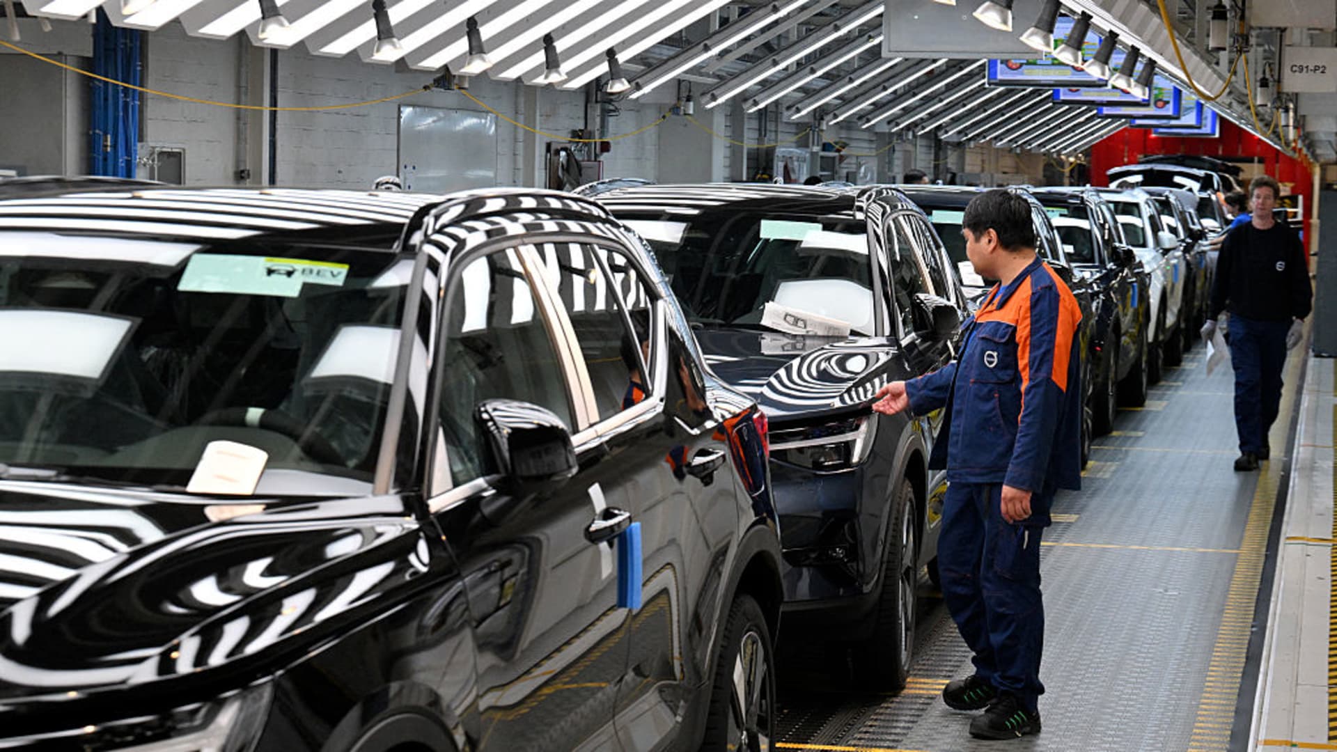 Workers inspect cars at the end of the production line of the Volvo factory in Ghent on April 25, 2025. 