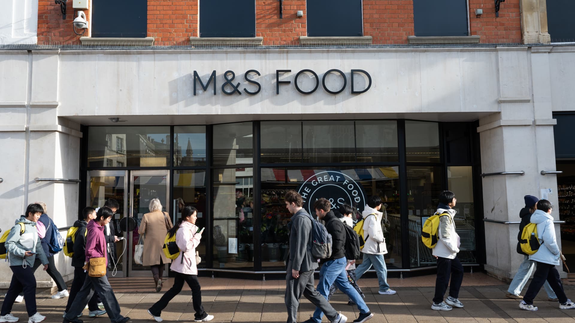 People walk past a Marks & Spencer store.