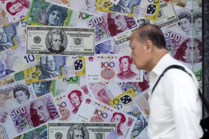 FILE PHOTO: A man walks past an advertisement promoting China's renminbi (RMB) or yuan, US dollar and Euro exchange services at a foreign exchange store in Hong Kong, China, Aug 13, 2015. (Reuters)