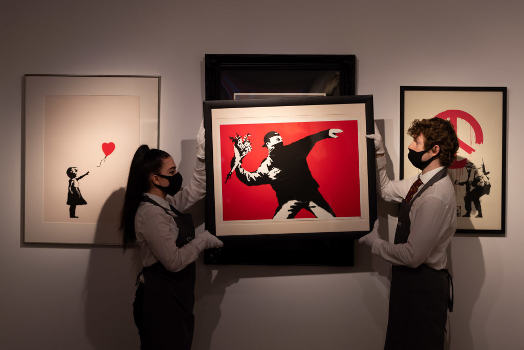 Love is in the Air by Banksy is displayed during preparations ahead of online sales at Christies Auction House on March 26, 2021 in London, England.