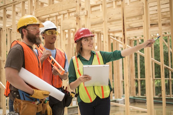 Workers inside framed building at construction site.