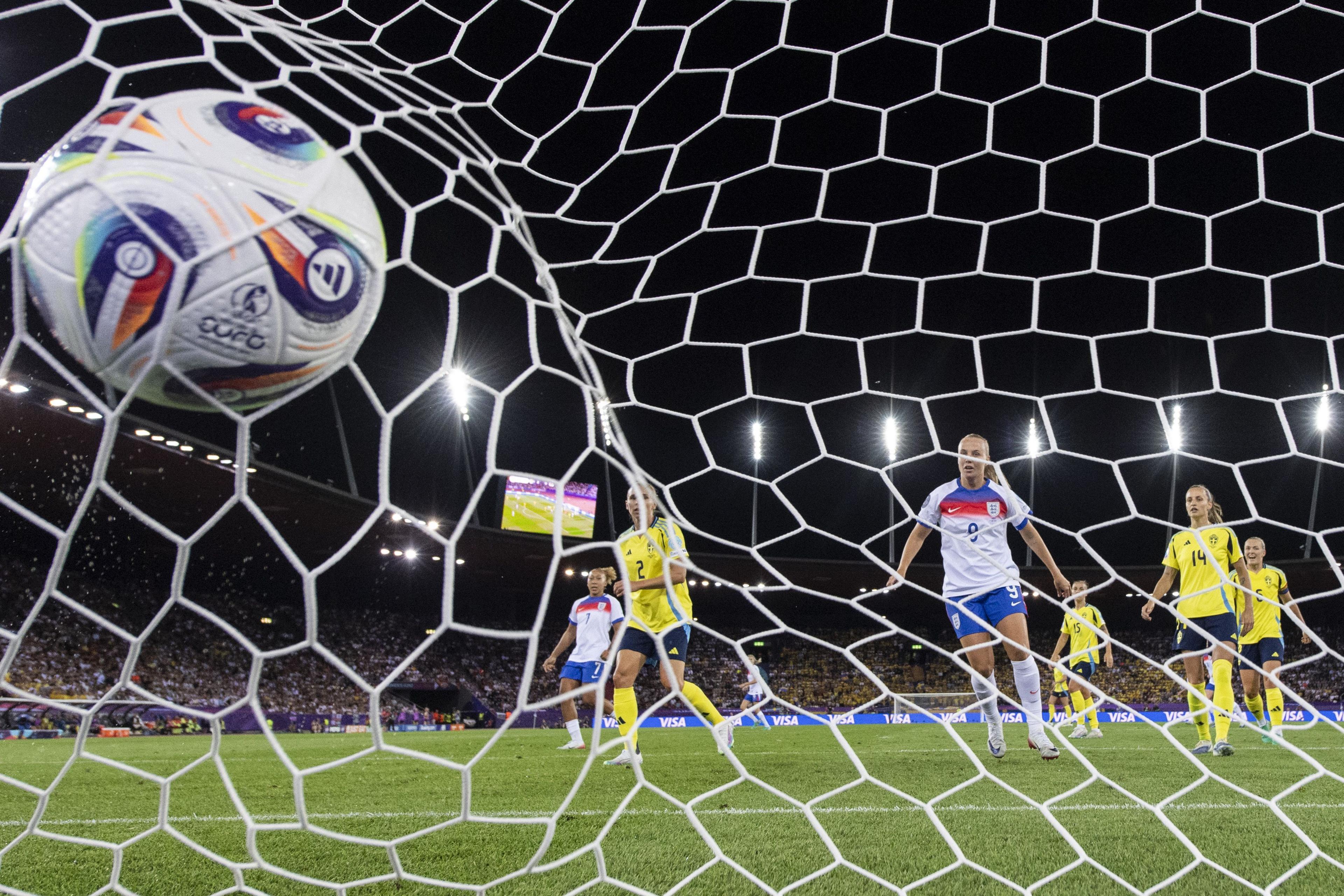 a euro 2025 branded football hits the back of the net in the stadium as england and sweden players look on with shock