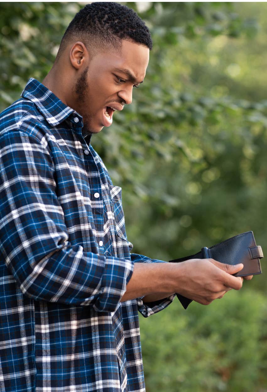 man realizing his cash has been stolen