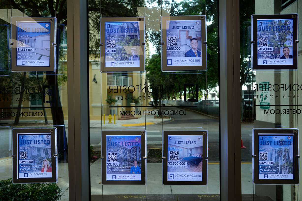 Digital signs advertising homes for sale adorn the window of a London Foster realty office, in Kendall, Fla., Oct. 19, 2023.