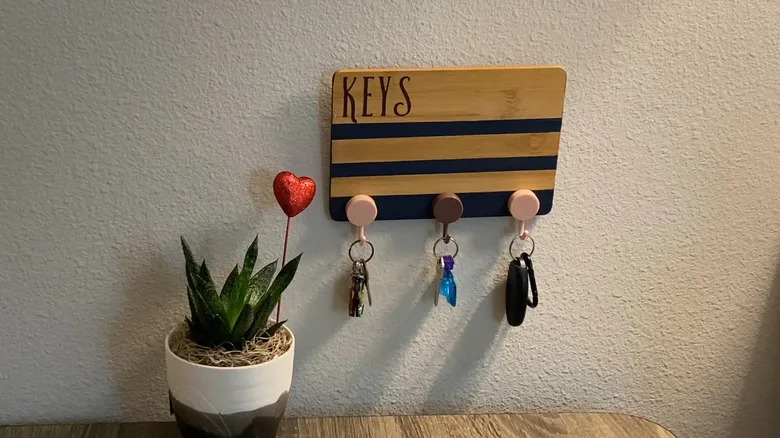 DIY key holder mounted on wall with three hooks for keys