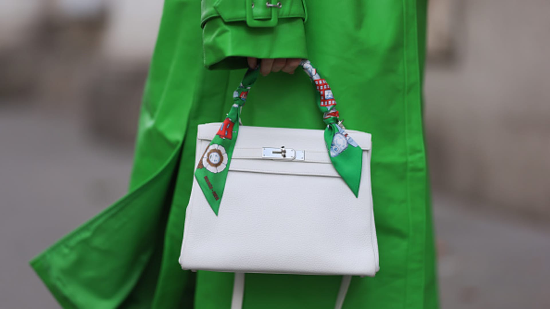 VIENNA, AUSTRIA - MARCH 11: A Hermès white leather Kelly bag worn with a Hermès green colorful Twilly ribbon, on March 11, 2023 in Vienna, Austria.