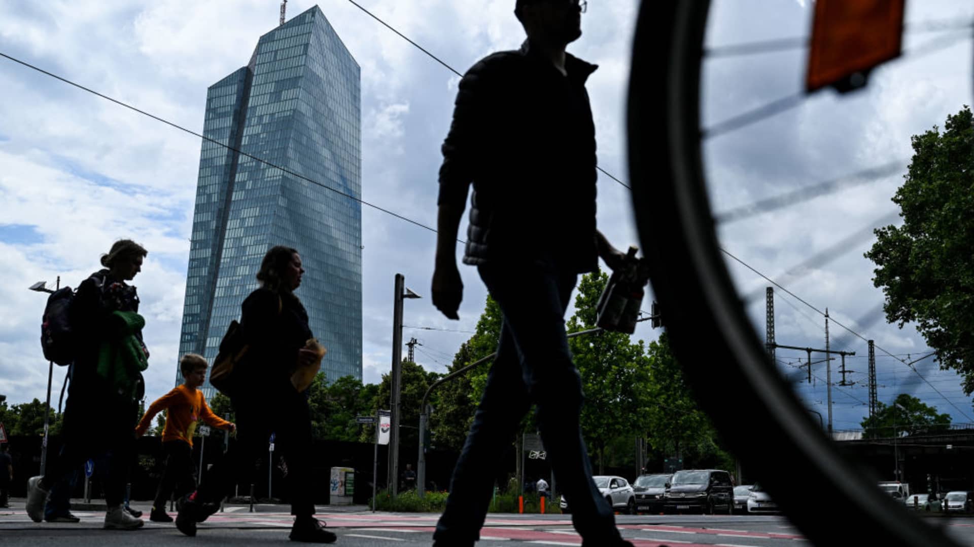 People cross a street in front the headquarters building of the European Central Bank (ECB) in Frankfurt am Main, western Germany, on June 5, 2024.