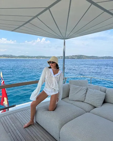 Influencer wearing white t-shirt, dotted slip skirt, and kitten heels while on European vacation.