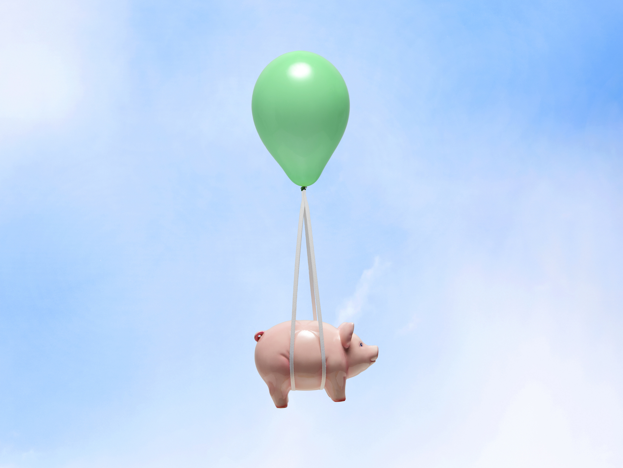 Piggy bank being lifted up by a balloon.