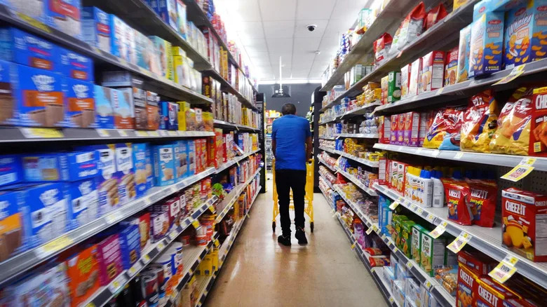 A shopper walking down a dollar store aisle