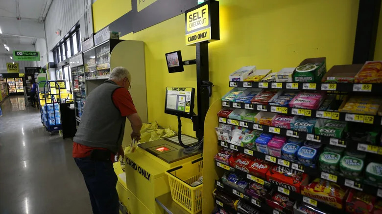 A man using a dollar store self checkout counter