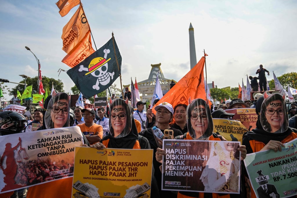 Workers wearing masks depicting Indonesian Finance Minister Sri Mulyani take part in a protest in Surabaya on August 28. Photo: AFP