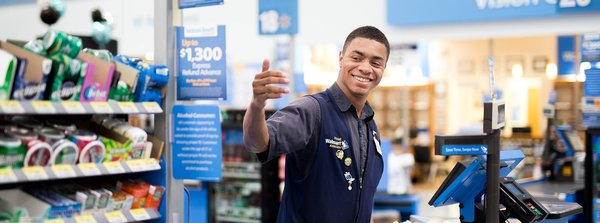 Smiling Walmart cashier signaling for next customer.