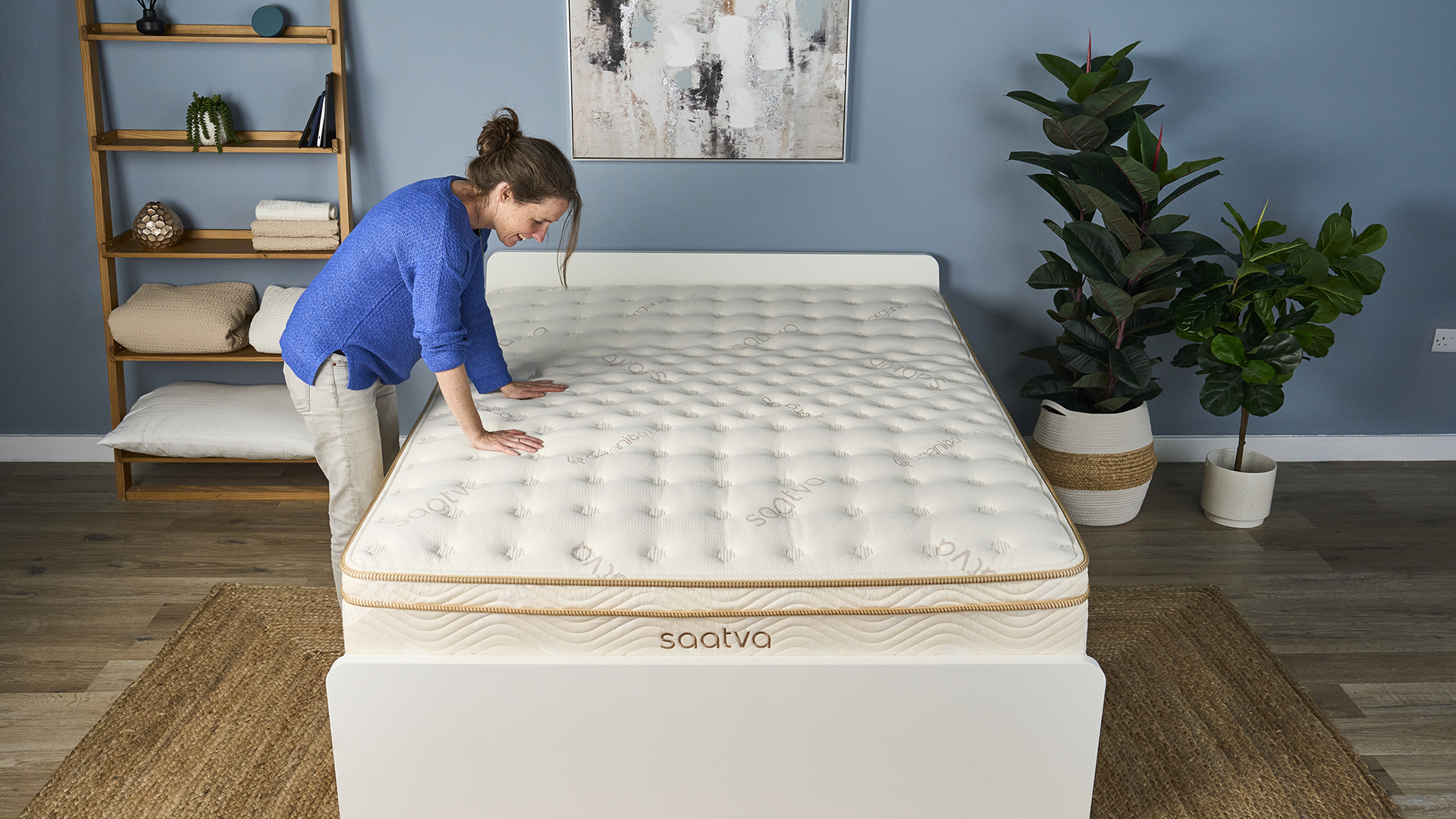 Tom's Guide Mattress Content Director Julia Sagar places both hands on the middle third of the Saatva Classic, where the lumbar crown is located, and smiles because it feels so supportive