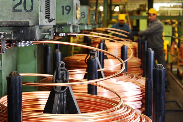 A picture of a copper wire factory producing spools of copper wire.