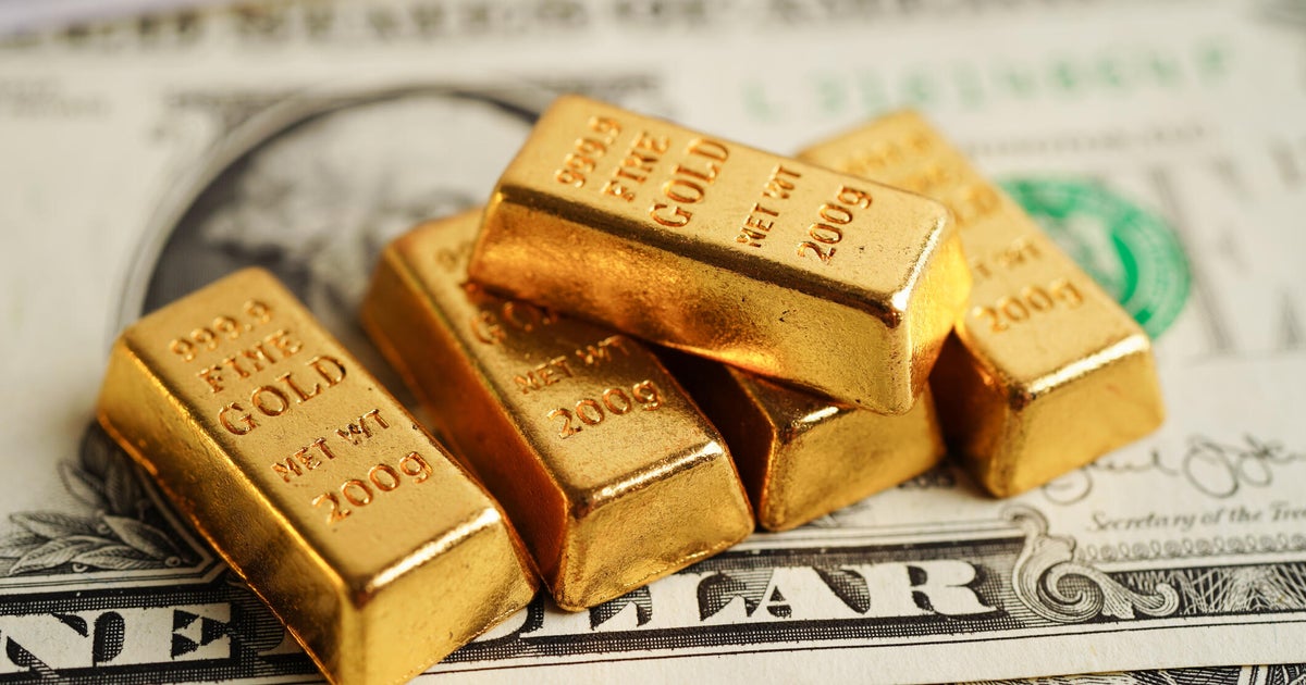 Gold bars on US dollar banknote money, finance trading investment business currency concept.