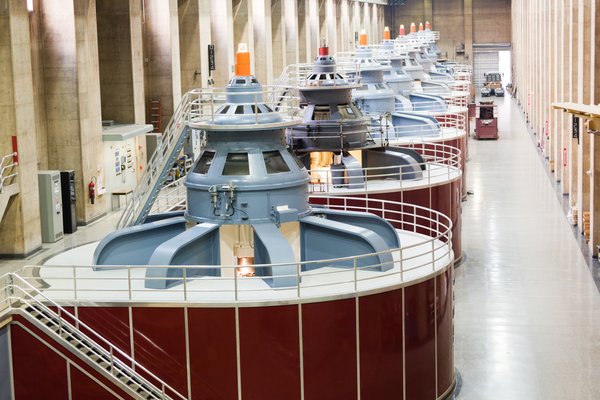 A row of huge industrial turbines in a building.