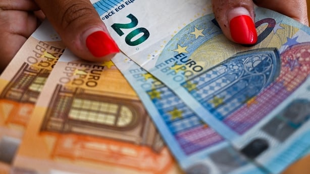 A woman holds in her hands and counts 50 euro and 20 euro banknotes