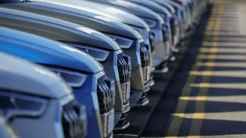 Getty Images A row of cars at car dealership
